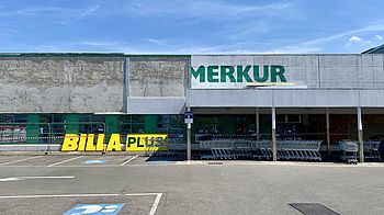 Parkplatz vor Billa Plus und Merkur mit Einkaufswägen