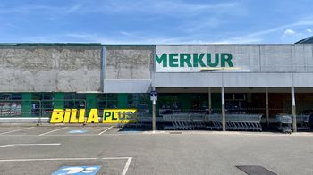 Parkplatz vor Billa Plus und Merkur mit Einkaufswägen