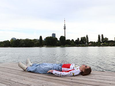 Die Musikerin Aygyul liegt am Badesteg an der Oberen Alten Donau. 