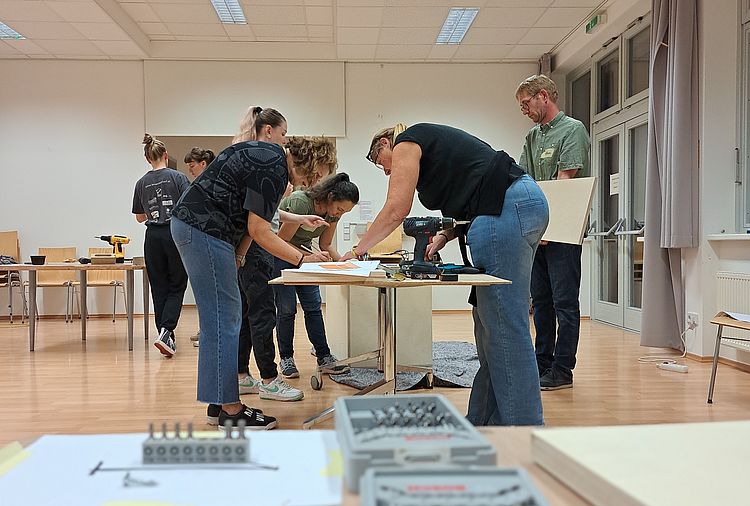 Eine Gruppe bearbeitet eine Holzplatte. 