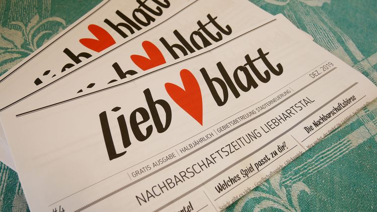 LiebBlatt #4 3 Exemplare der Zeitung LiebBlatt liegen auf einem Tisch mit türkis-weiß gemusterten Tischtuch