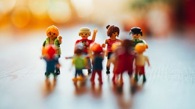 Playmobilfiguren in unetrschiedlichen Ausführungen und Größen wirken wie eine im Kreis stehende, gestikulierende und im Gespräch vertiefte Menschengruppe.