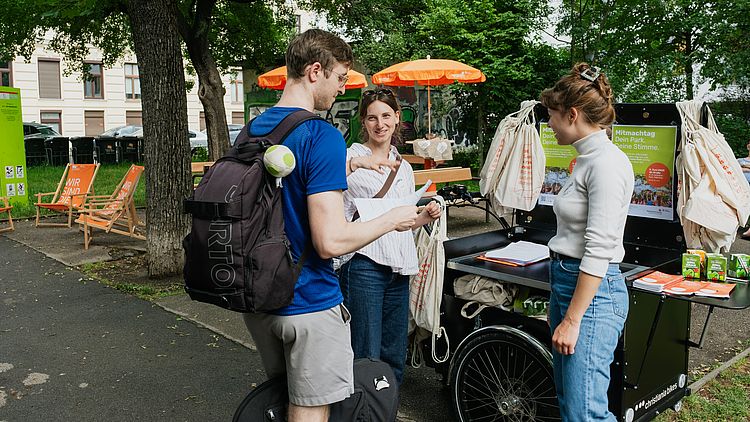 Interessierter Bewohner mit GB*-Mitarbeiterinnen am Infostand.