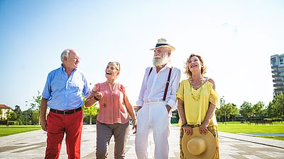 Vier Senioren spazieren voller Energie.