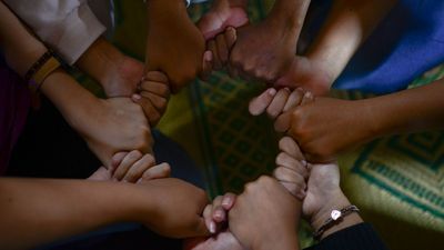 viele geschlossene Hände die gemeinsam einen Kreis bilden