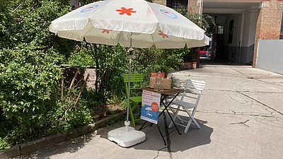 Sonnenschirm mit Tisch und Sessel.