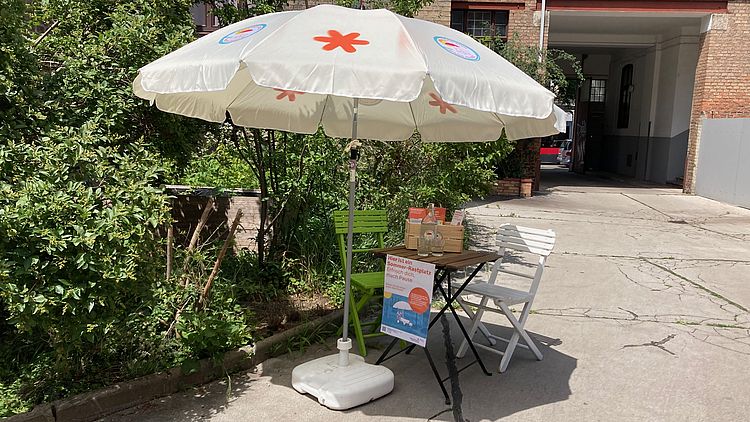 Sonnenschirm mit Tisch und Sessel.