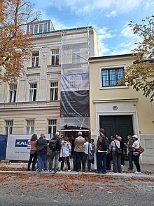 Eine Gruppe Menschen steht vor einem Sanierungsprojekt in Döbling.